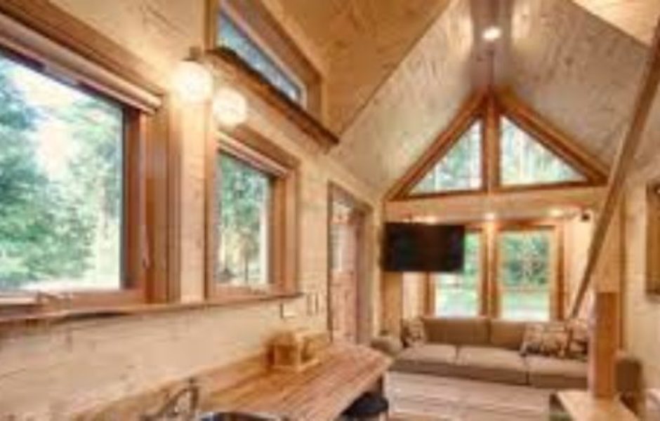 A living room with wood paneling and windows.