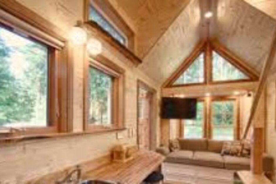A living room with wood paneling and windows.