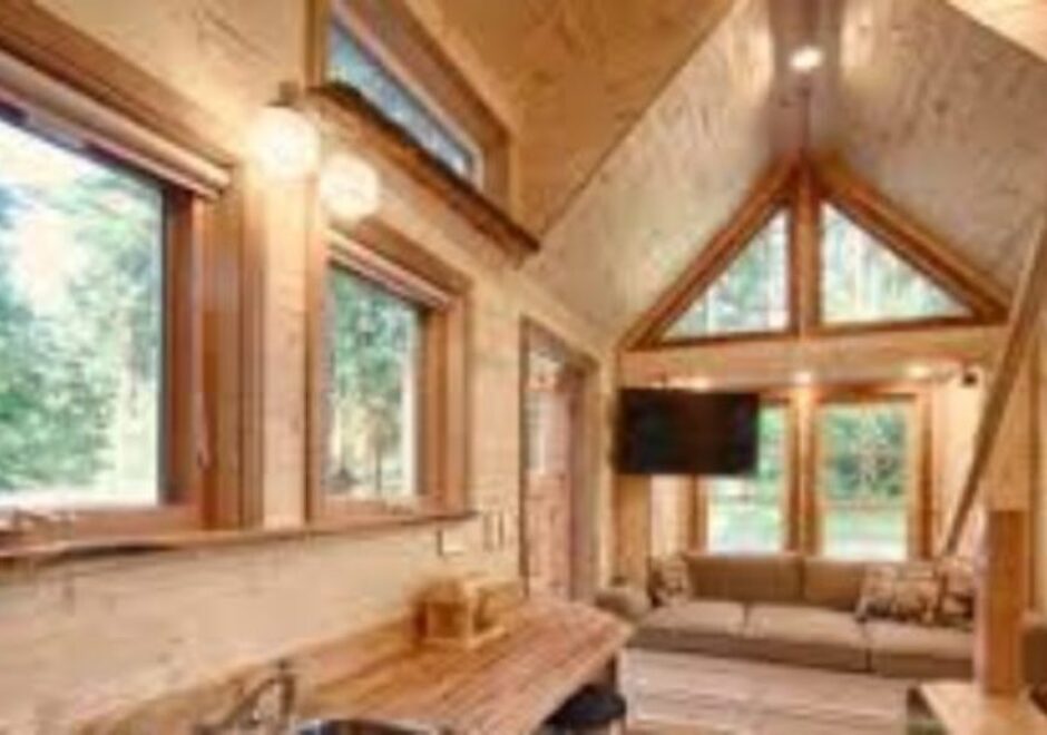 A living room with wood paneling and windows.