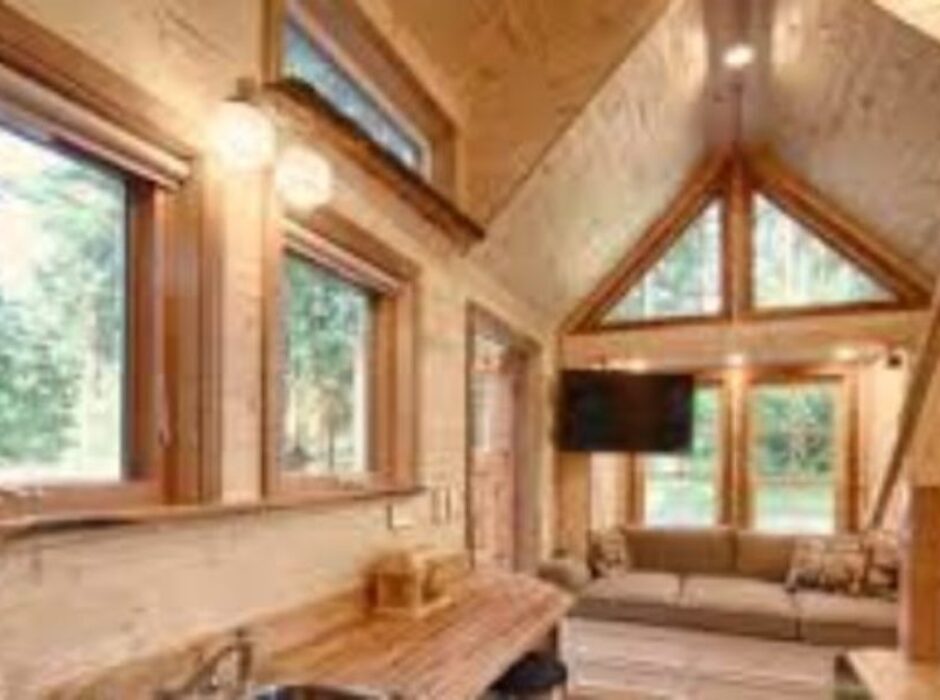 A living room with wood paneling and windows.