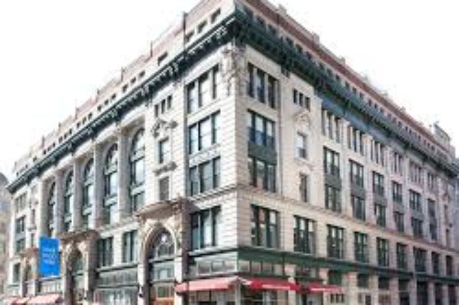 A large building with many windows and a red awning.