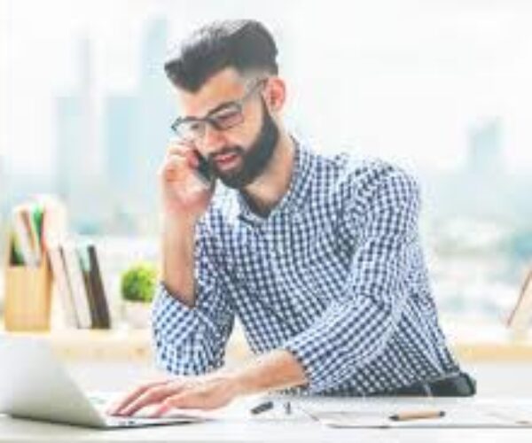 A man sitting at his desk on the phone