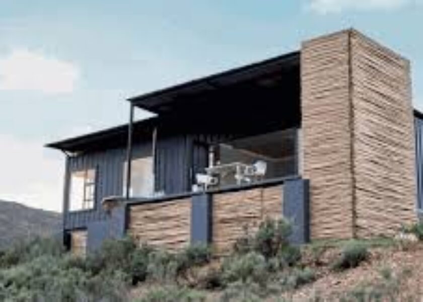 A house built from shipping containers on top of a hill.