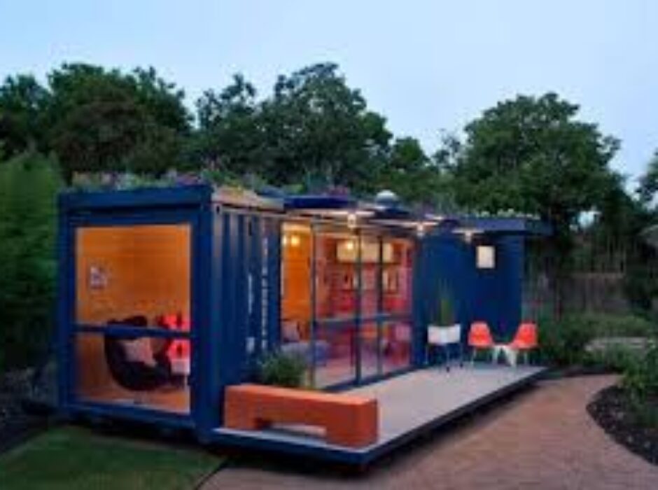 A blue container house with patio furniture and outdoor seating.