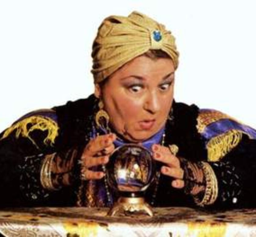 A woman with a turban on looking at a crystal ball.