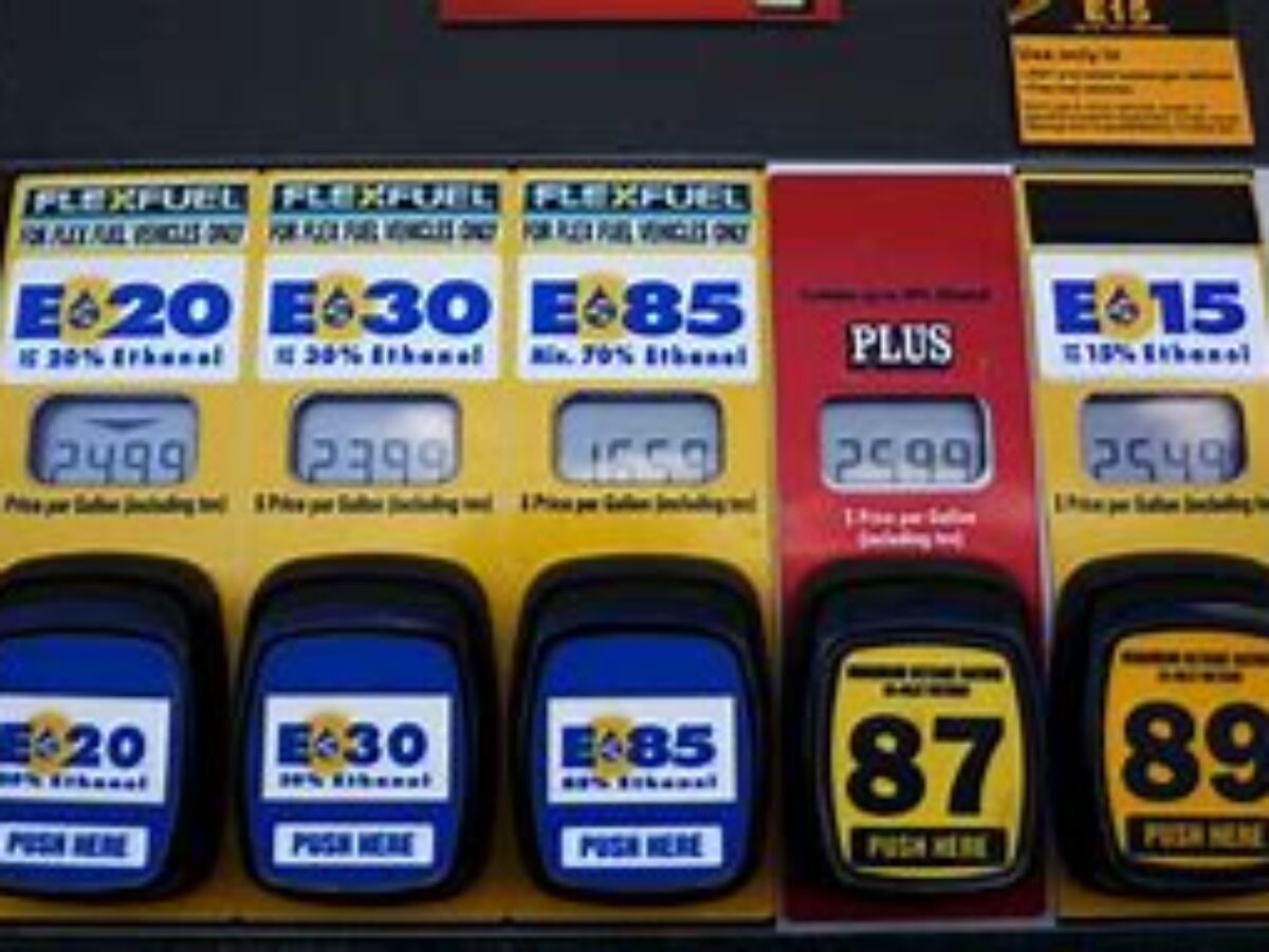 A row of gas pumps with prices on them.