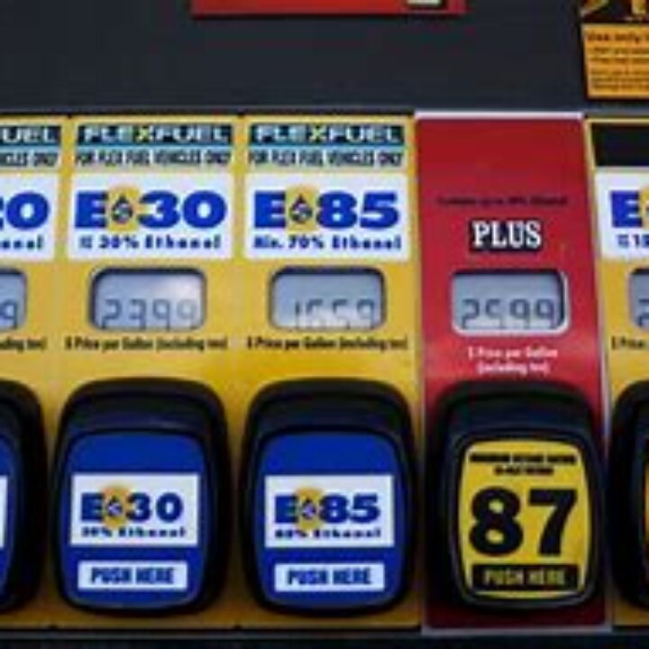 A row of gas pumps with prices on them.