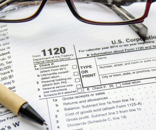 A pair of glasses and pen on top of an irs form.