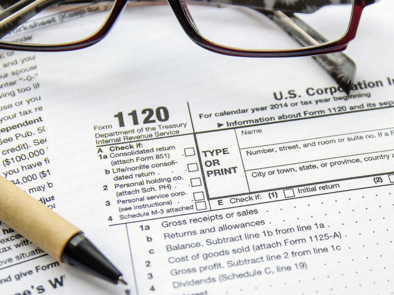 A pair of glasses and pen on top of an irs form.