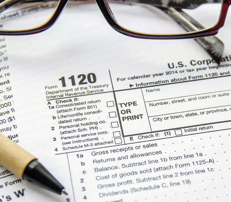 A pair of glasses and pen on top of an irs form.