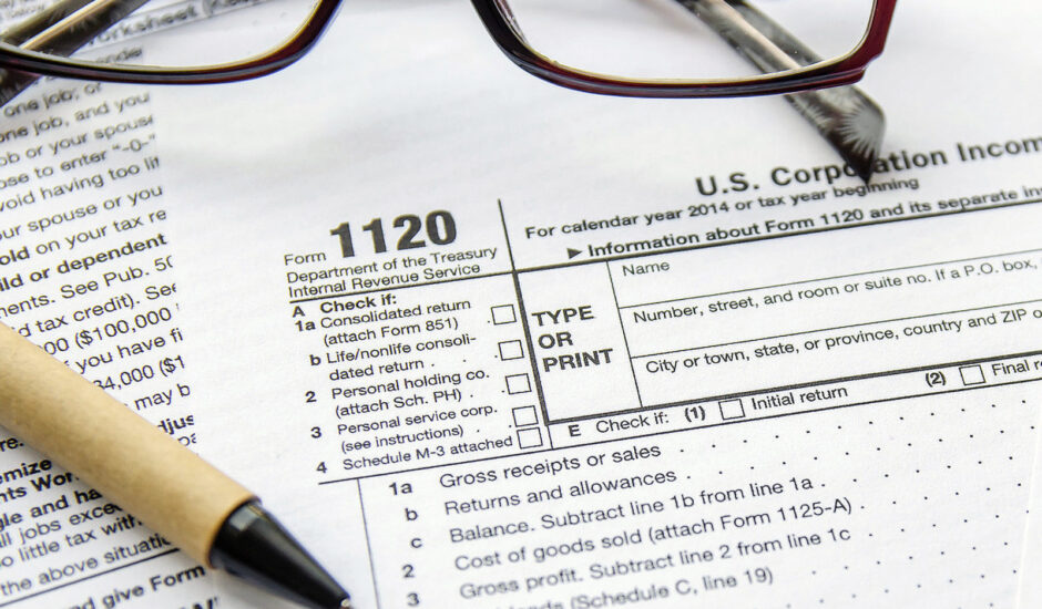 A pair of glasses and pen on top of an irs form.