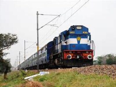 A train is traveling down the tracks near some power lines.