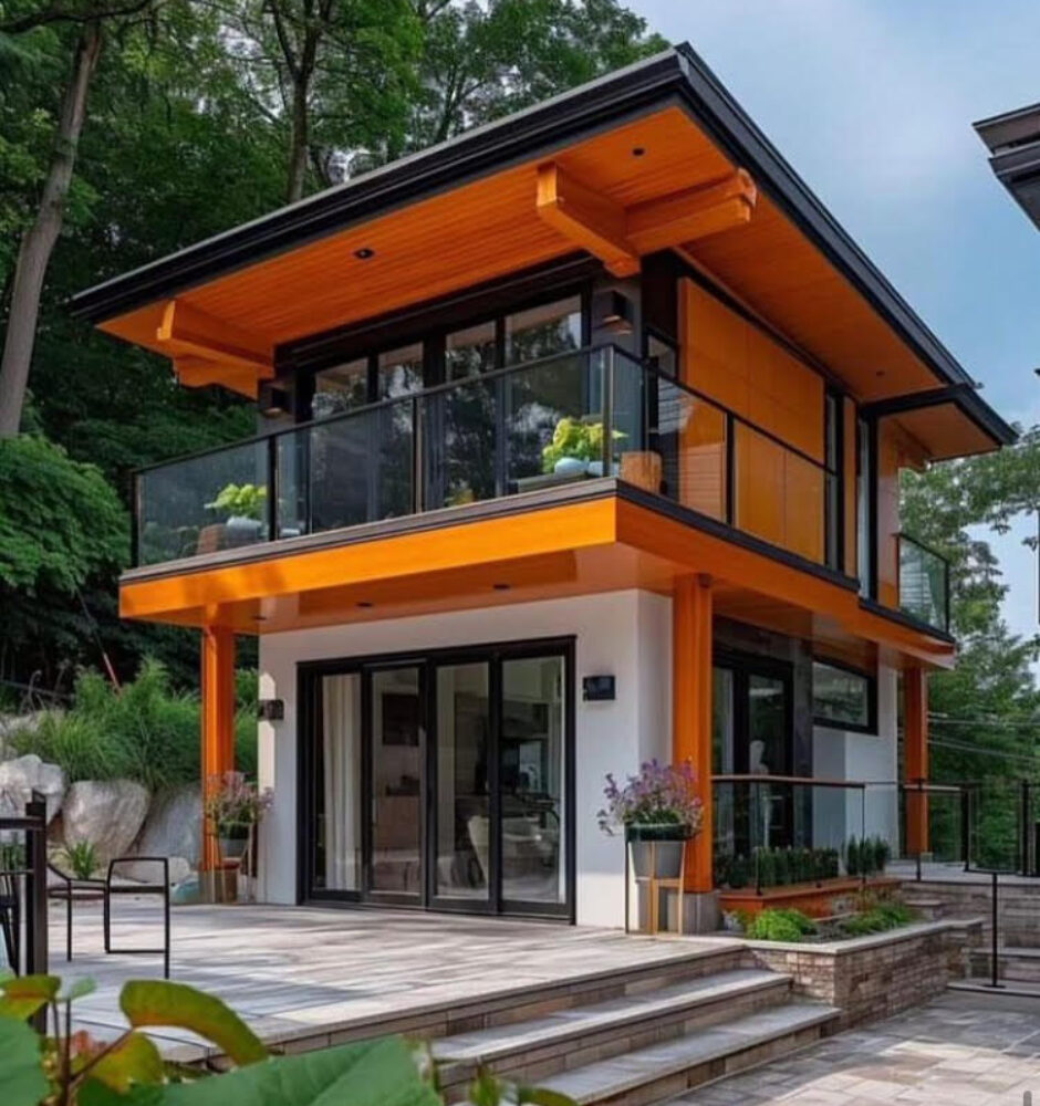 A house with a glass balcony and steps leading to the front door.