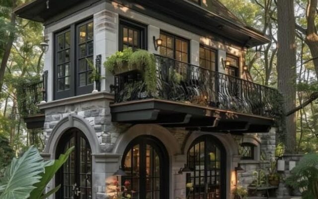A house with stairs and balcony in the middle of trees.