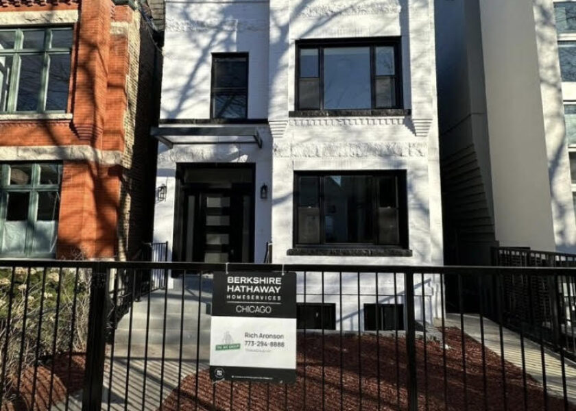 A white building with black trim and a fence.