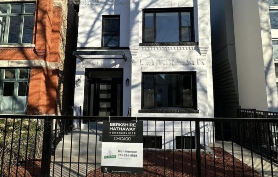 A white building with black trim and a fence.