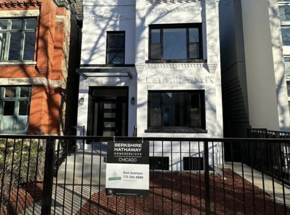 A white building with black trim and a fence.