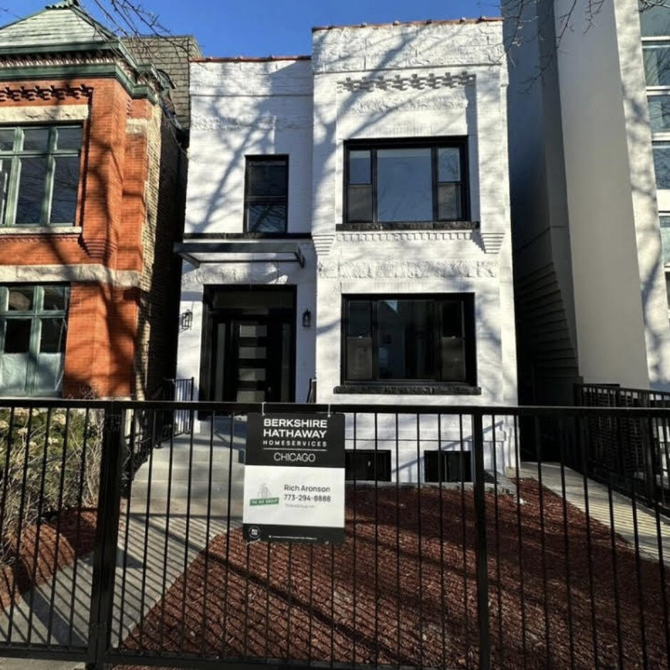 A white building with black trim and a fence.
